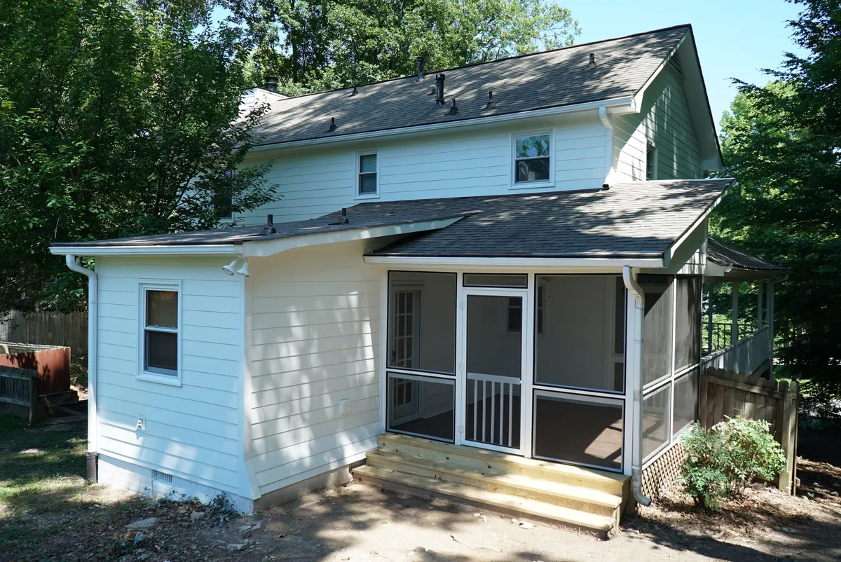After: new white siding and a screened porch.