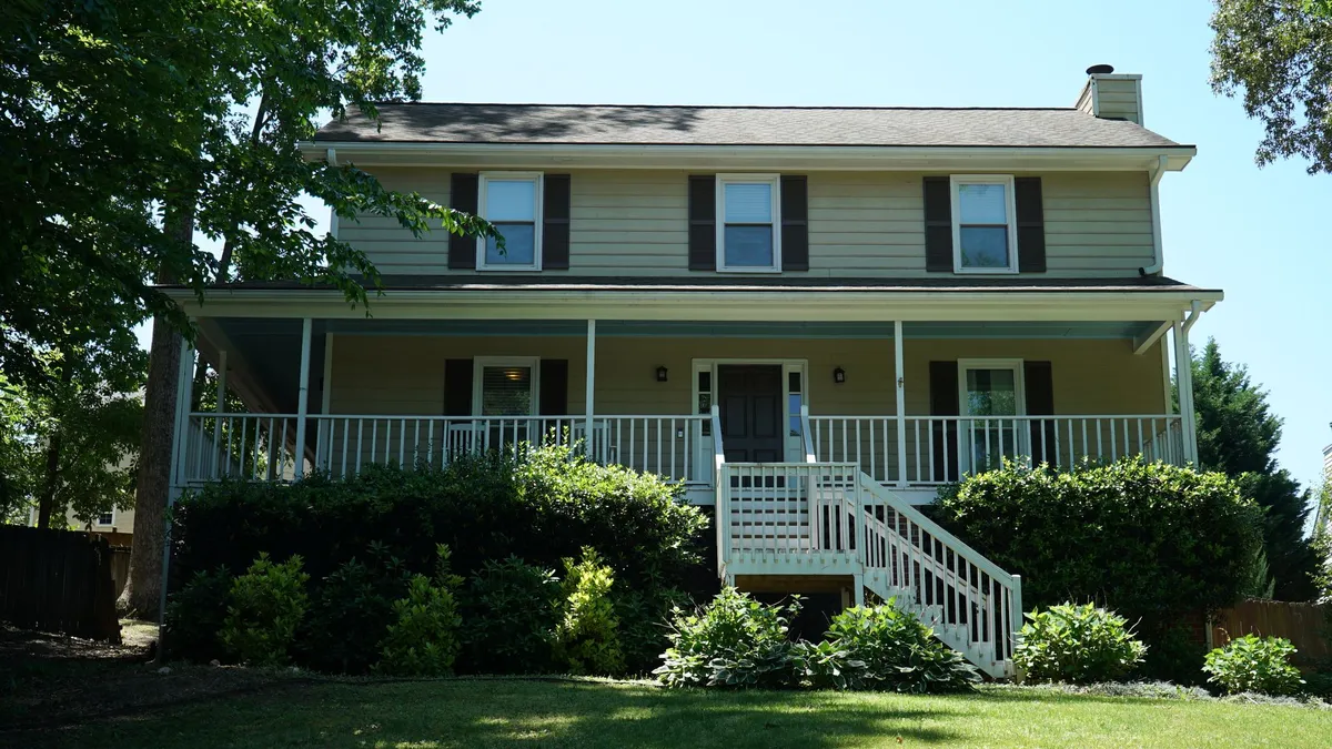 Before: olive siding across the front and porch.