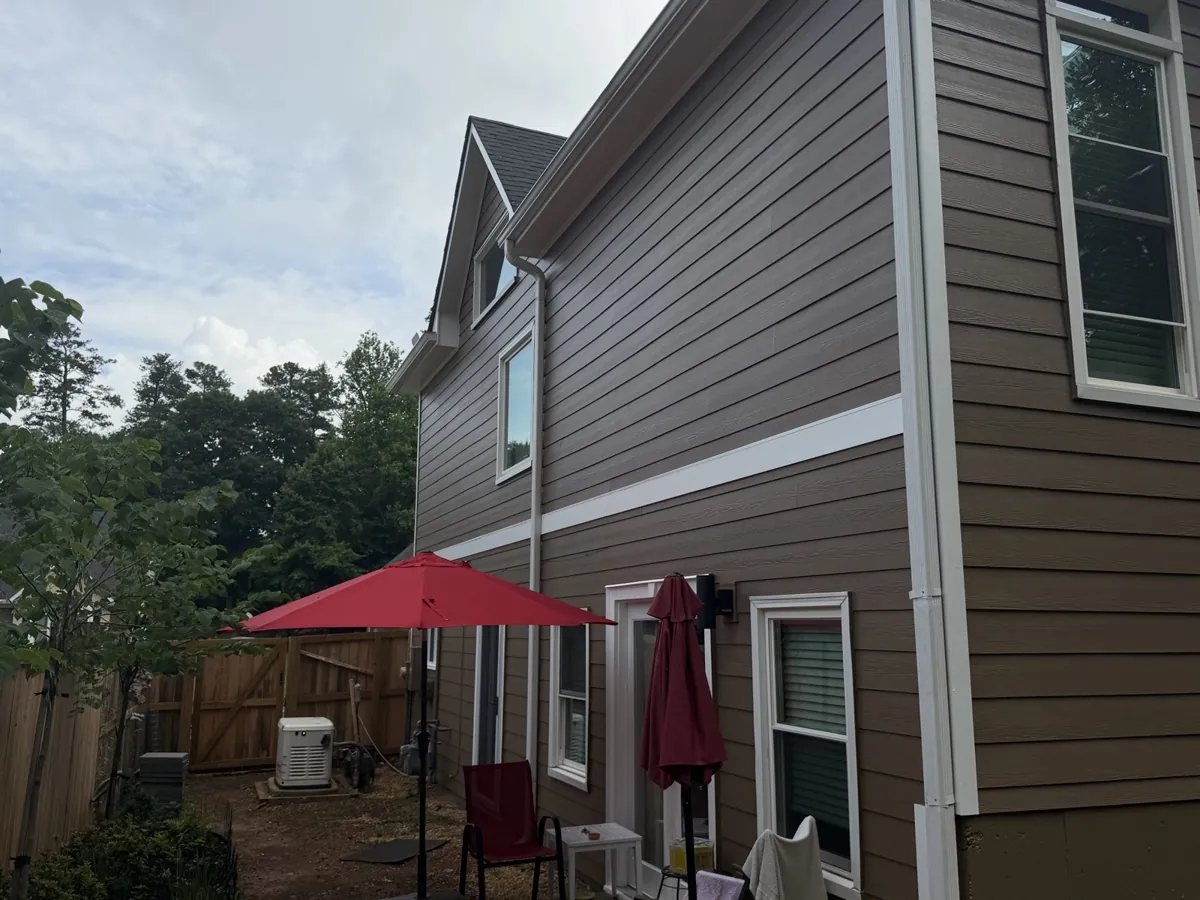 After: the same side in new lap siding and white trim.