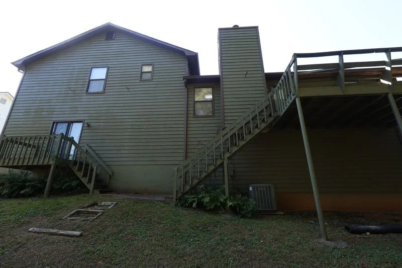 Before: the rear of the home, original siding around the deck.