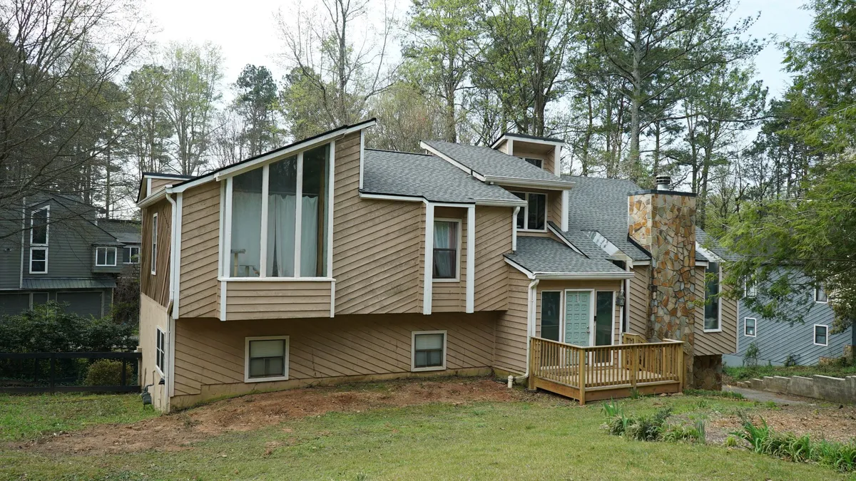 Before: faded tan diagonal wood siding on the front.