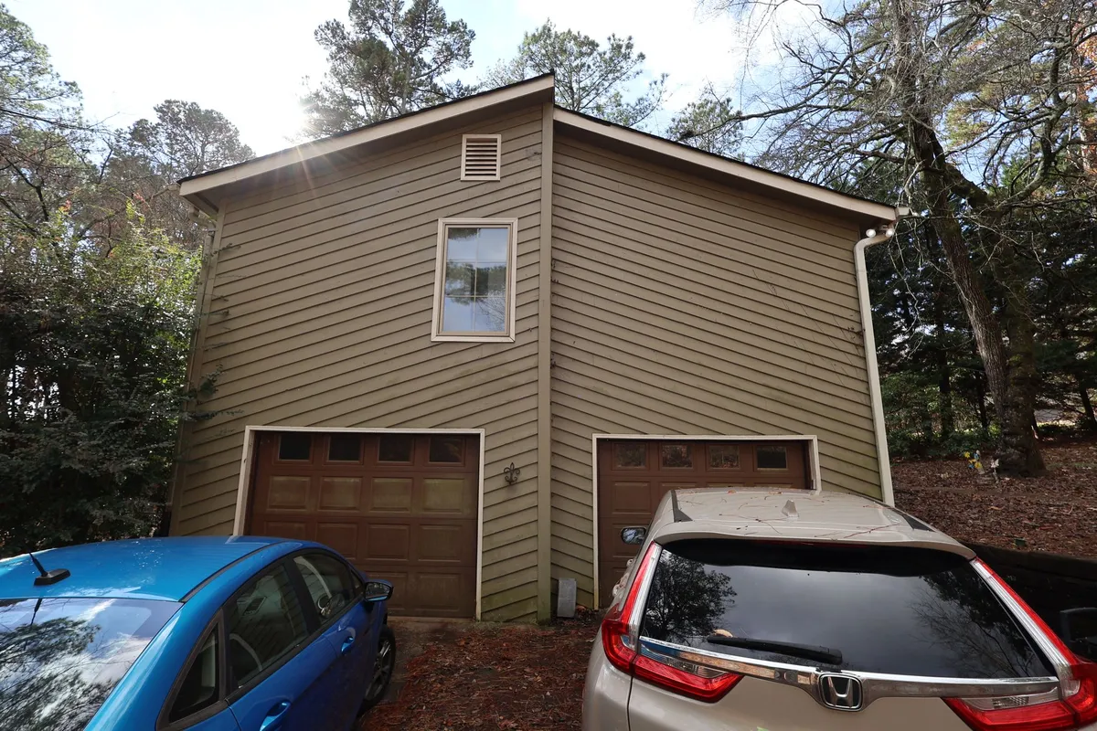 Before: the detached garage in olive-tan siding.