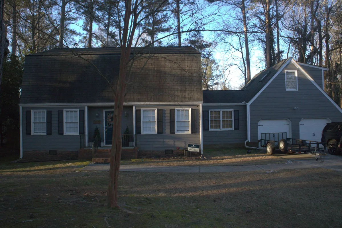 Before: dark slate siding on the house and garage.