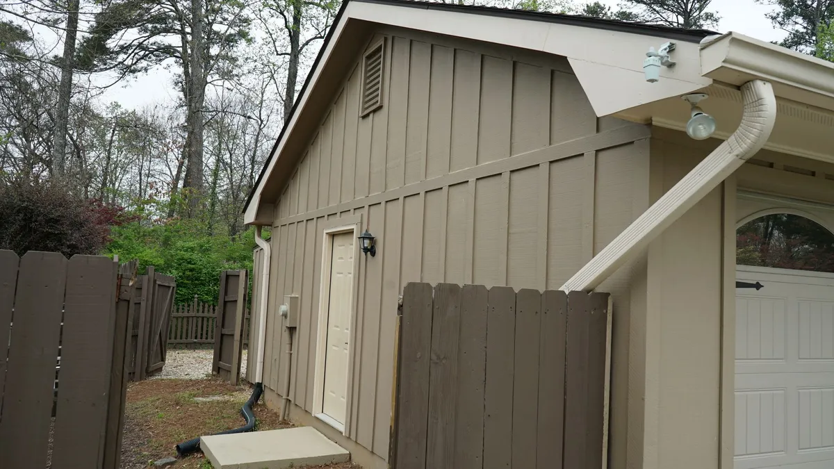 Before: tan vertical siding on the garage side.