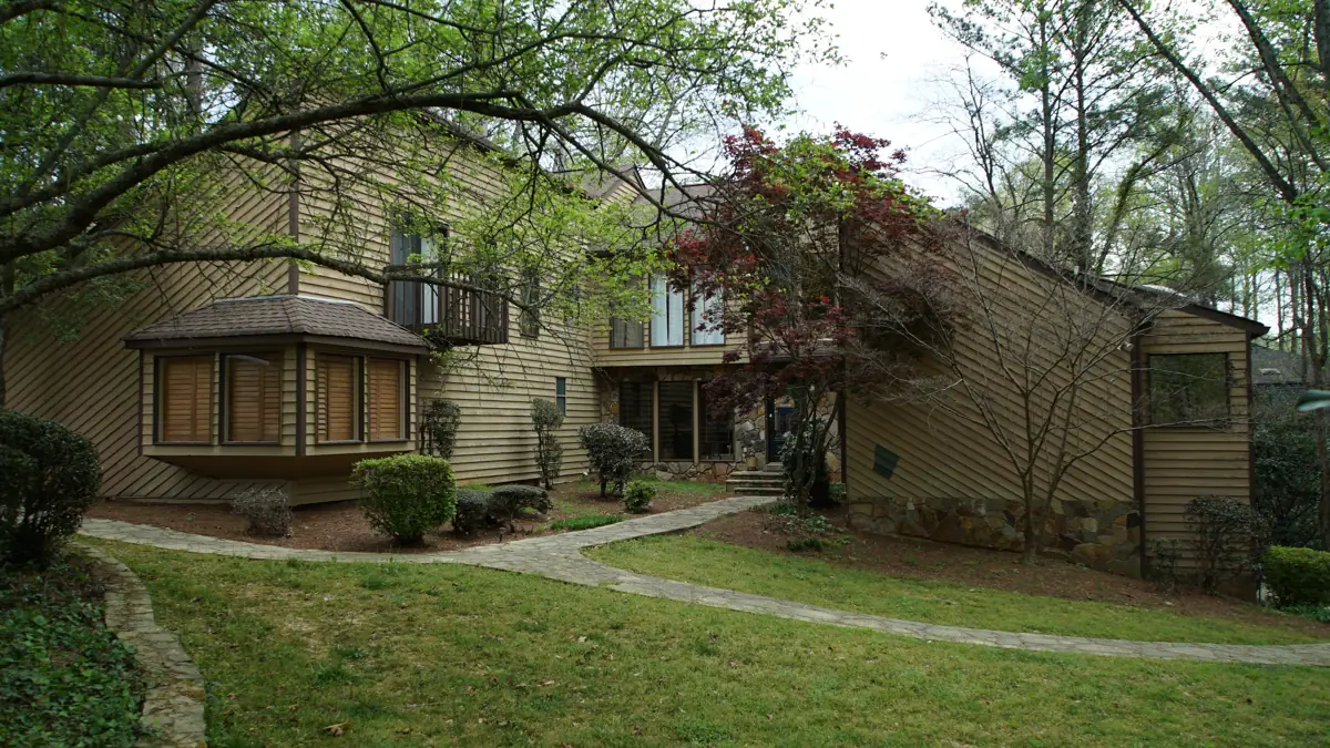Before: Front of a two-story Roswell home on a wooded lot